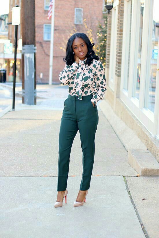 Great green outfit with dark green pants and floral dressy blouse .