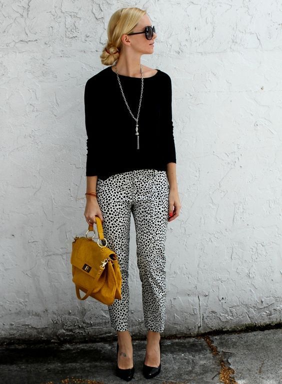 Picture Of dalmatin printed cropped pants, a black top and heels .