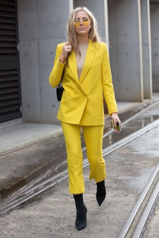 a neon yellow pantsuit, a neutral top and black sock boots for a .