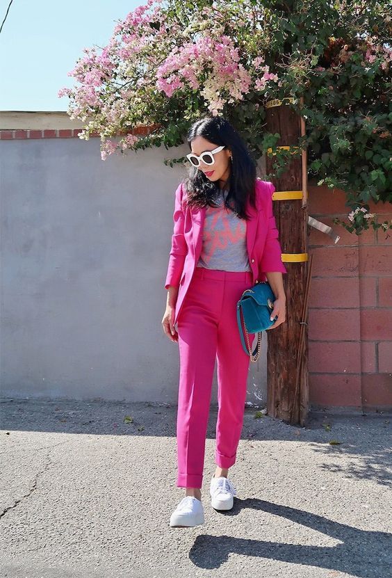a hot pink pantsuit with a printed tee, a blue bag and white .