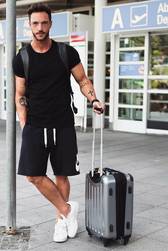 a black t shirt, black Nike shorts, white sneakers and a backpack .