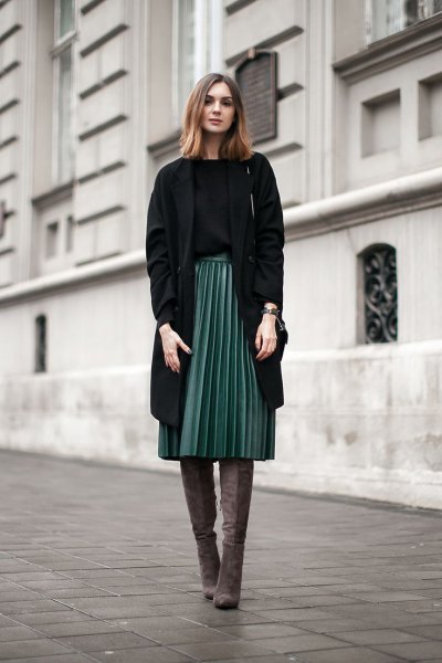 black longline blazer with a gray pleated skirt and overknee boots