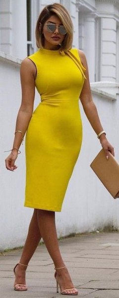 sleeveless bodycon yellow midi dress with faux neckline and mustard clutch