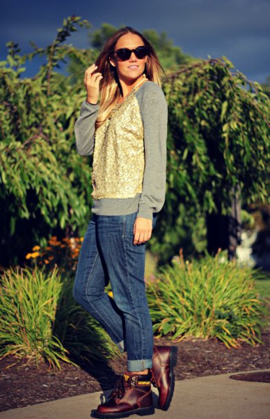 gray sweatshirt with gold vest and blue cuffed jeans