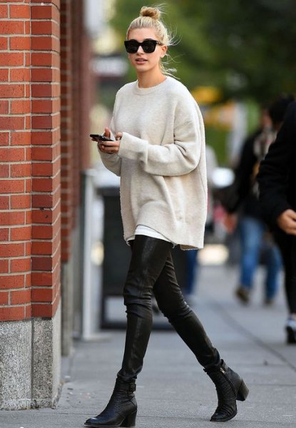 Cream colored oversized knit sweater with black leather leggings