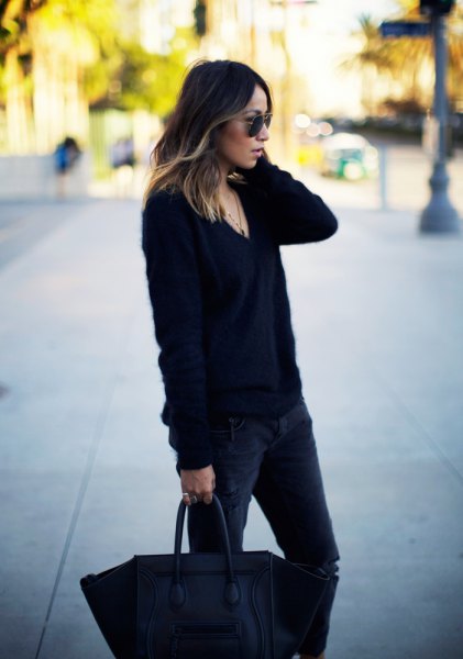 black chunky knit V-neck sweater and dark slim-fit jeans