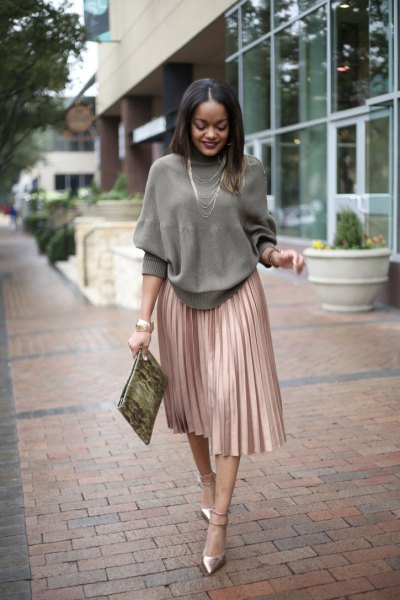 Gray knitted sweater with a round neckline and a rose gold-colored pleated skirt