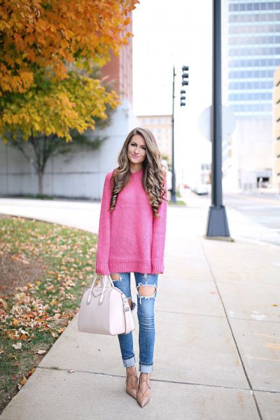 pink chunky knit sweater with blue badly ripped jeans