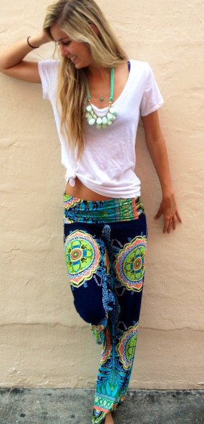 white knotted t-shirt with black and yellow beach pants with tribal print