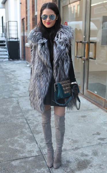 gray long faux fur vest with black sweater dress and overknee boots
