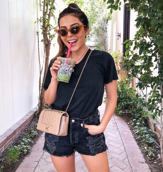 black t-shirt with ripped denim shorts and pink wallet