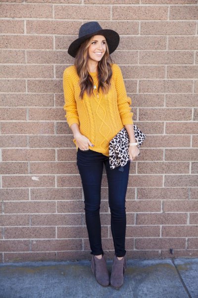 Cable knit sweater with a black felt hat and skinny dark jeans