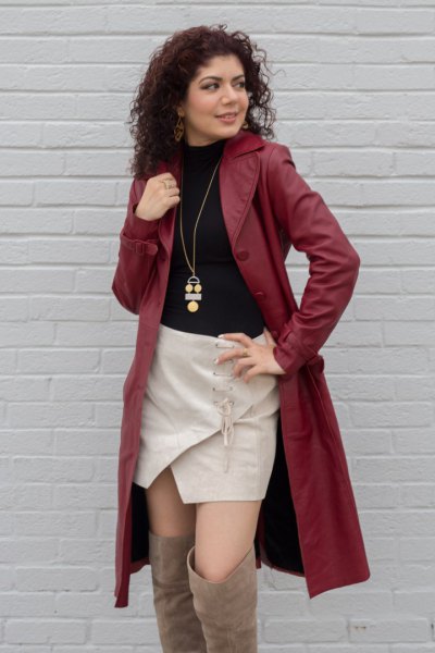 brown leather trench coat with black sweater and pink skort