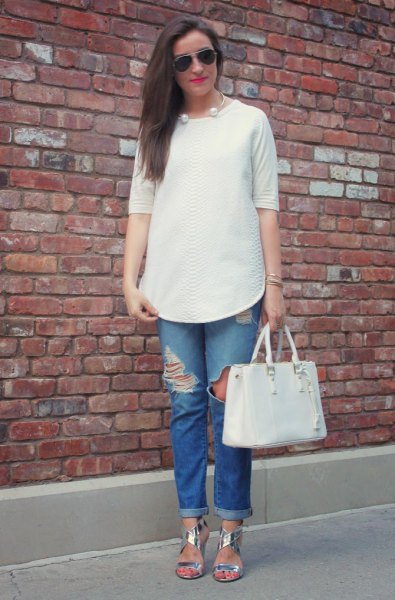 white buttonless blouse with half sleeves and ripped blue jeans with cuffs