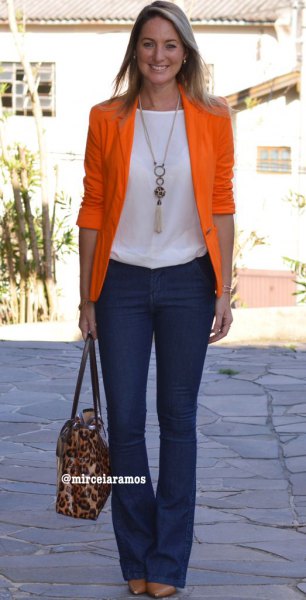 Orange half sleeve blazer with white top and dark blue flared jeans