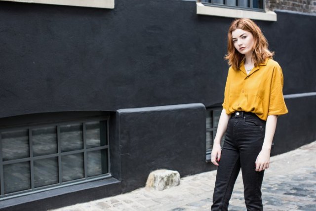 Mustard shirt with wide sleeves and black high-rise jeans