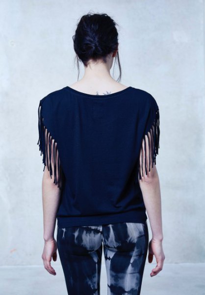 Skinny trousers with a black blouse with fringed sleeves
