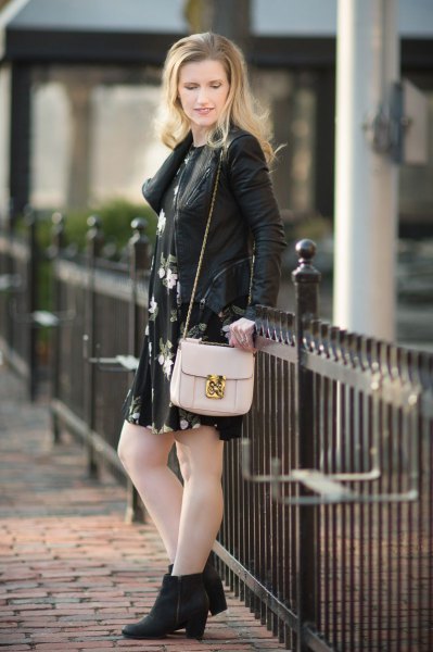 Leather jacket worn with a black floral swing mini dress and heeled boots