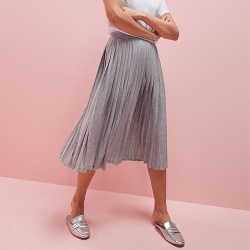 white t-shirt with light gray pleated skirt and silver dress shoes