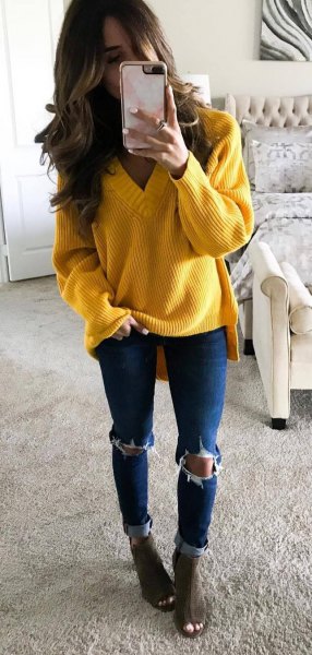 Yellow chunky knit V-neck sweater paired with blue skinny jeans