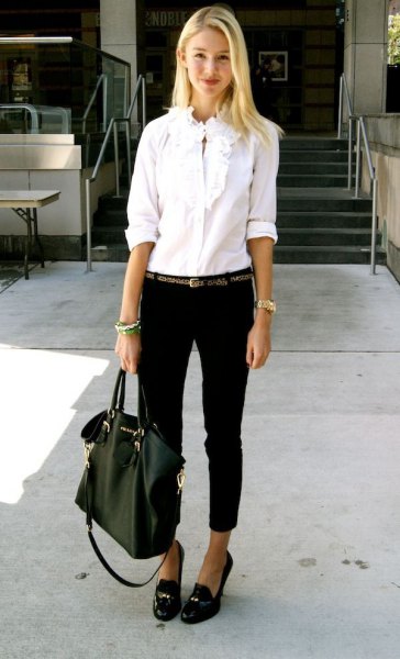 white shirt with ruffled buttons, black jeans with cuffs and slippers with tassels