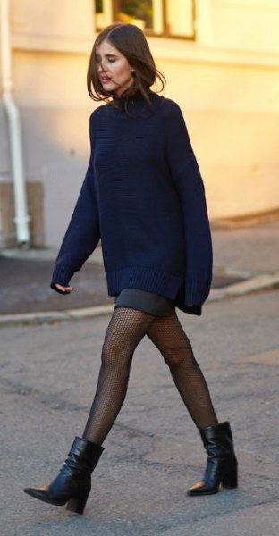 Chunky knit sweater with a gray mini skirt and ankle boots