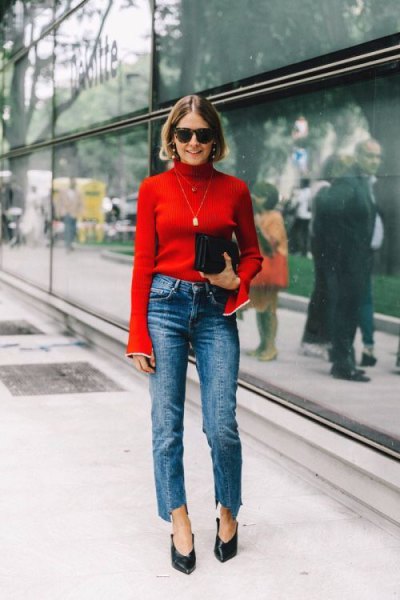 red bell-sleeve sweater with blue neckline and blue-leg straight-leg jeans