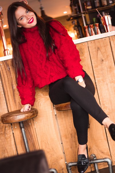 red knit sweater with a stand-up collar and black slim fit jeans