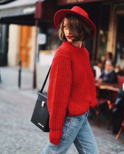 red felt hat with a chunky red sweater with light blue jeans