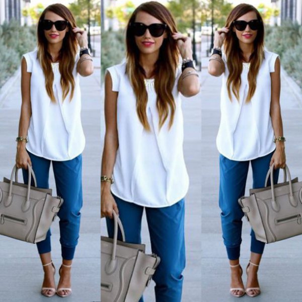 white sleeveless chiffon blouse with blue trousers with tapered legs