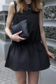 black tank top with mini skirt and leather handbag