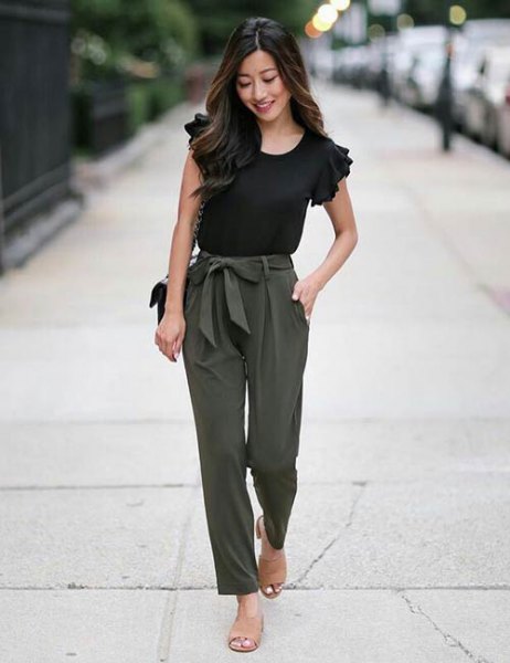 black t-shirt with ruffled sleeves and army green slim-fit trousers in front