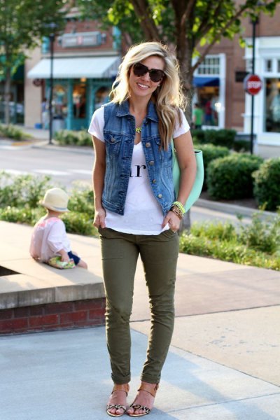 white printed t-shirt with denim vest and green skinny jeans