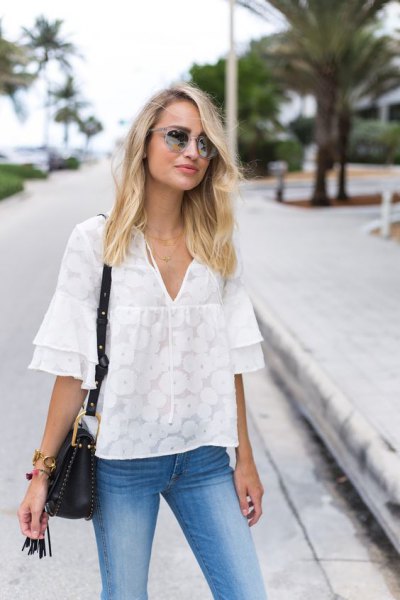 Oversized blouse with white ruffled sleeves and light blue skinny jeans
