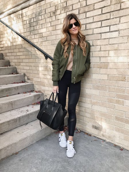 green bomber jacket with blush pink fitted sweater and running shorts
