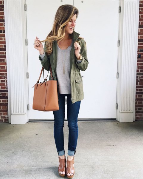Olive green jacket with a gray sweatshirt and dark blue skinny jeans with cuffs