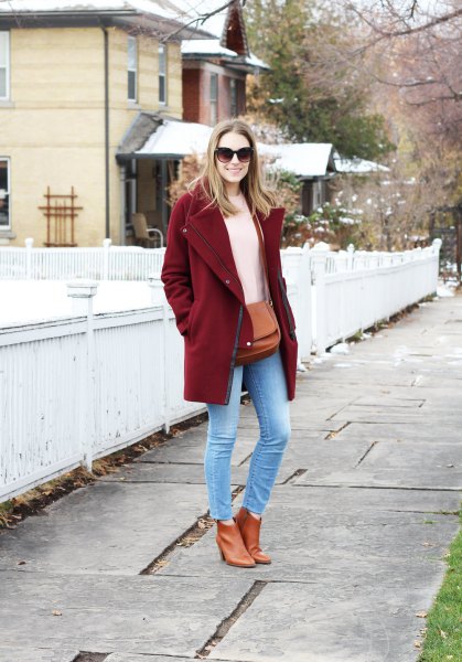 Burgundy coat with ivory knit sweater and light blue skinny jeans
