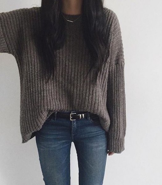 gray, coarsely knit sweater with dark blue drainpipe jeans and belt