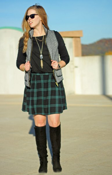 black long-sleeved t-shirt with green plaid skirt and gray vest