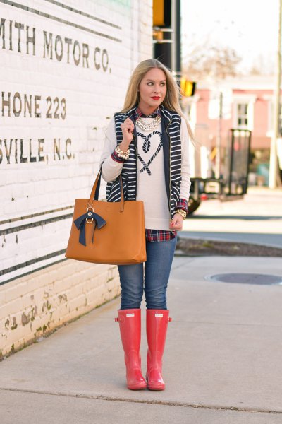 white embroidered sweater with blue jeans and orange knee high rain boots