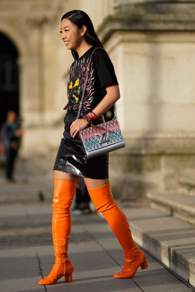 black t-shirt and leather skirt with orange leather overknee boots