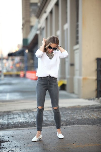 V-neck white knit sweater, gray ripped jeans