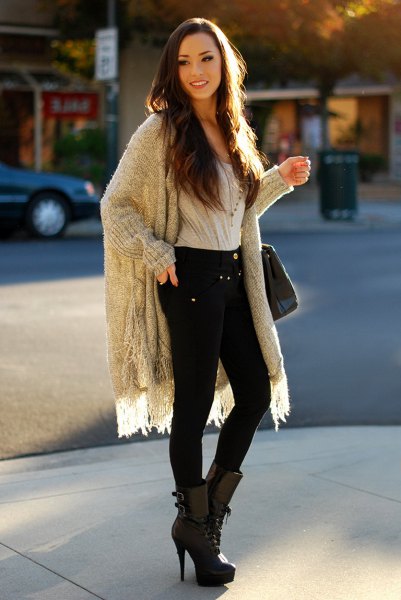 gray ribbed longline fringed sweater with black skinny jeans and high-heeled mid-calf boots
