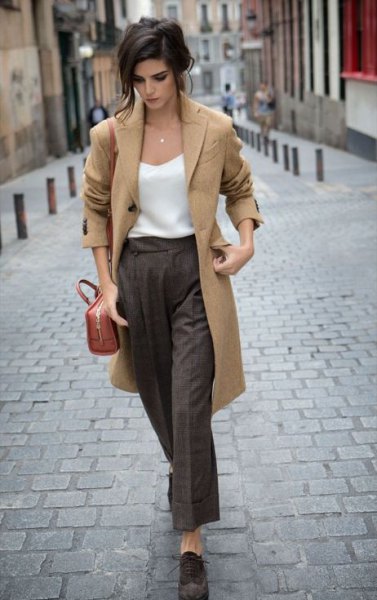 Camel longline wool coat with white waistcoat and gray wide leg trousers