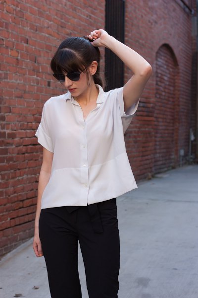 Short-sleeved silk blouse with buttons and black slim-fit jeans