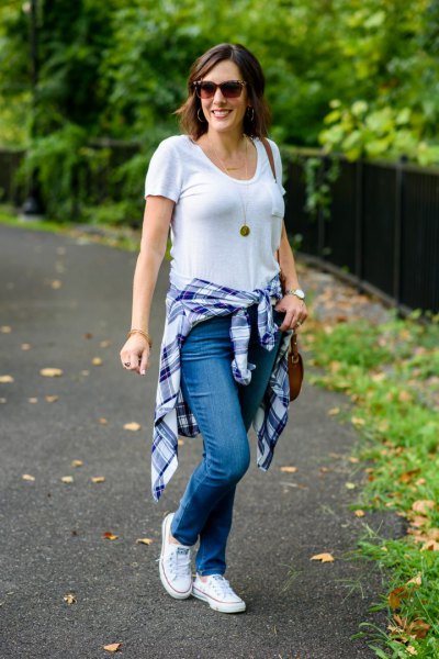 white v-neck t-shirt, jeans and blue plaid shirt tied at waist