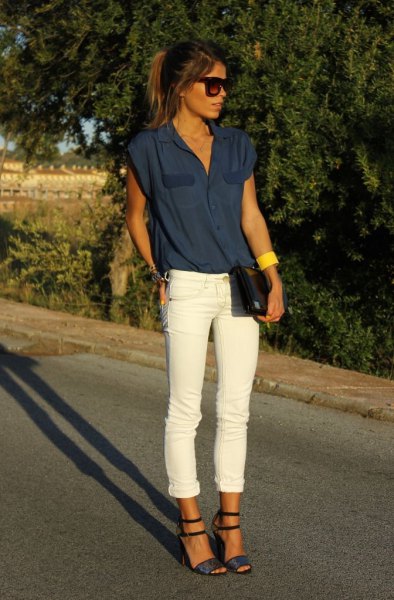 Dark blue sleeveless blouse with white cuffed jeans