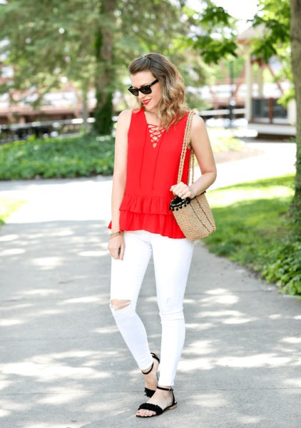 Red V-neck sleeveless blouse with white ripped front paired with white jeans