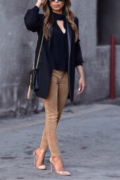 black blouse in front with tan skinny jeans