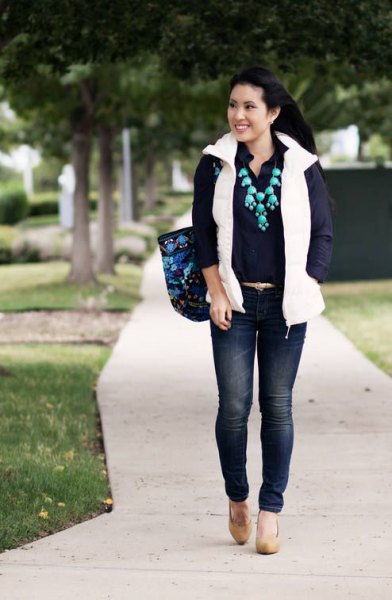 white puffer vest with button down shirt and dark blue skinny jeans